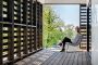 A lady sitting inside a room that has been designed by architects using pallets.