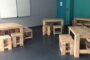 A Set Of Pallet Wood Chairs And Tables Placed On An Empty Classroom.